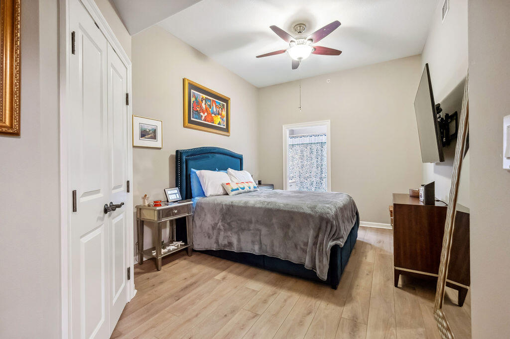 770 Harbor Boulevard, Unit 1D Destin, FL 32541 - Photo 24 of 59 a bedroom with a bed a flat screen tv and a dresser