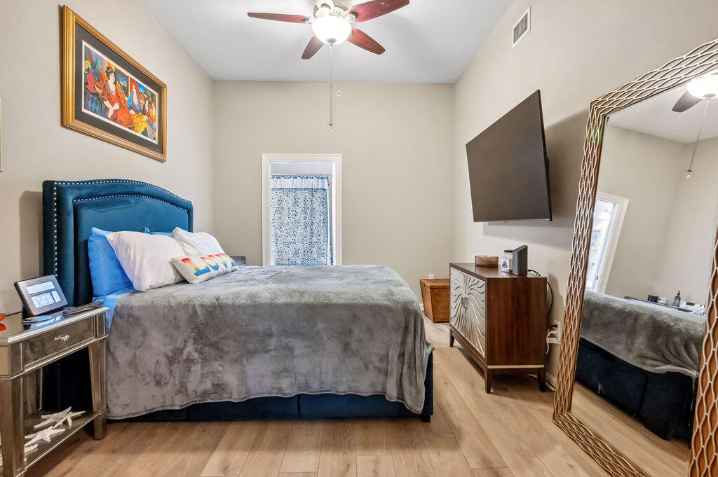 770 Harbor Boulevard, Unit 1D Destin, FL 32541 - Photo 25 of 59 a bedroom with a bed and a flat screen tv
