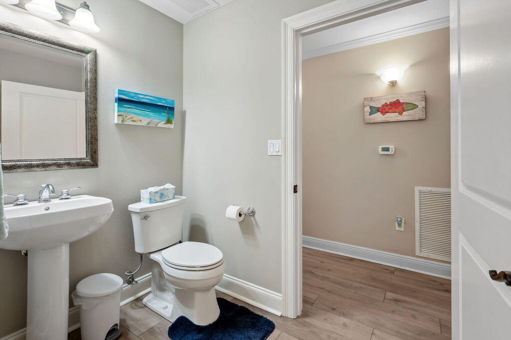 770 Harbor Boulevard, Unit 1D Destin, FL 32541 - Photo 28 of 59 a bathroom with a toilet sink and mirror