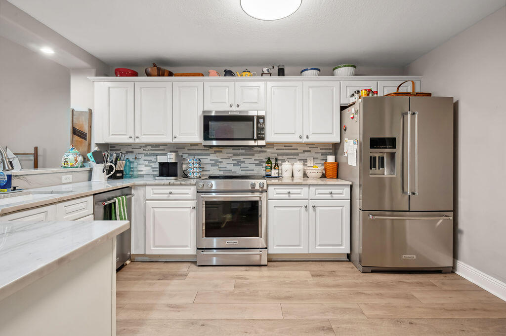 770 Harbor Boulevard, Unit 1D Destin, FL 32541 - Photo 33 of 59 a kitchen with cabinets stainless steel appliances and wooden floor