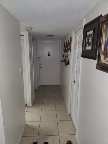 a view of a hallway with closet and bathroom