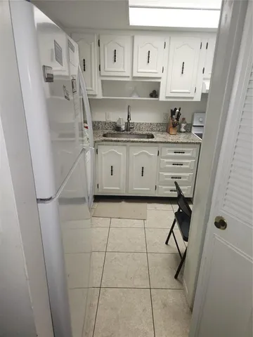 a kitchen with stainless steel appliances a refrigerator sink and cabinets
