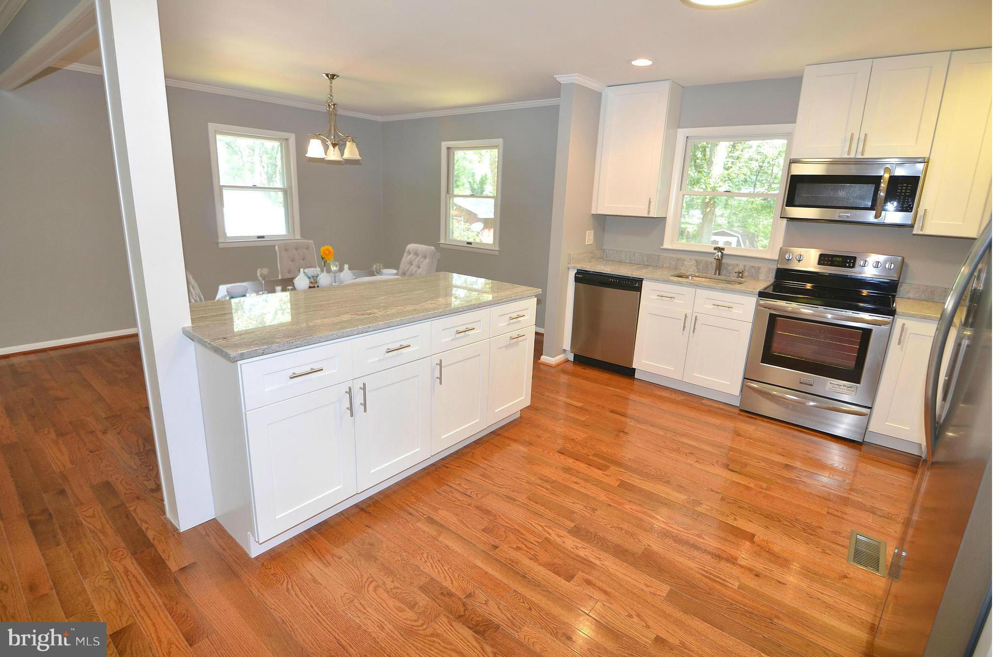 a large kitchen with granite countertop a stove top oven sink and cabinets