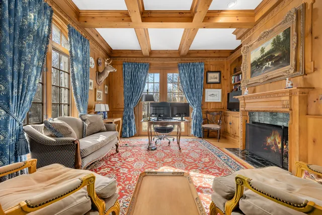 a living room with furniture a fireplace and a large window