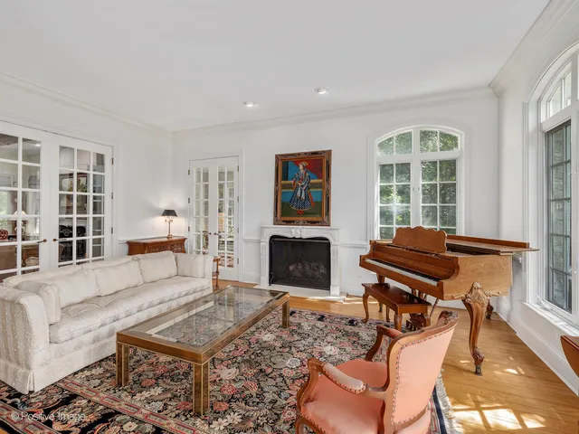 a living room with furniture a piano and a fireplace