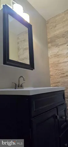 a bathroom with a sink vanity and a mirror