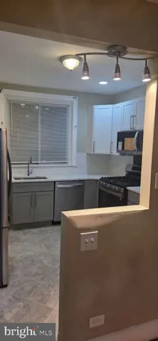 a kitchen with stainless steel appliances granite countertop a sink a stove and a refrigerator