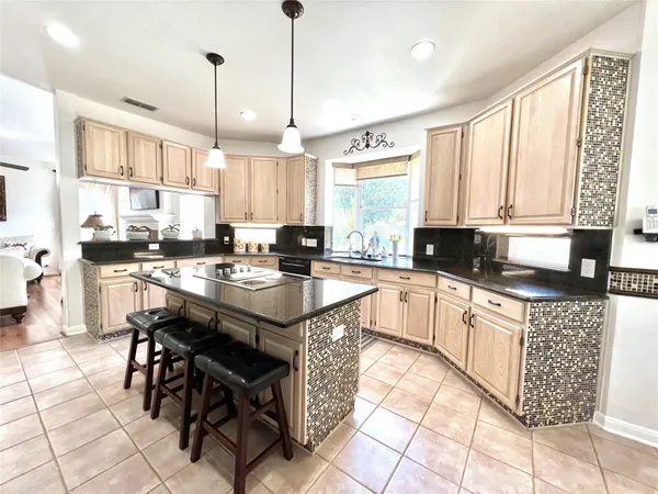 a kitchen with stainless steel appliances granite countertop a stove a sink a microwave and a refrigerator