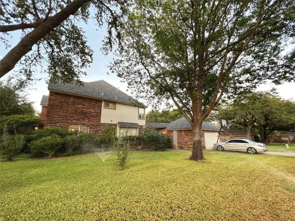 a car parked in front of a house with a yard