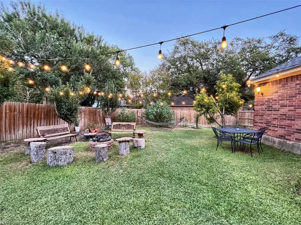 a view of a house with backyard furniture and a fire pit
