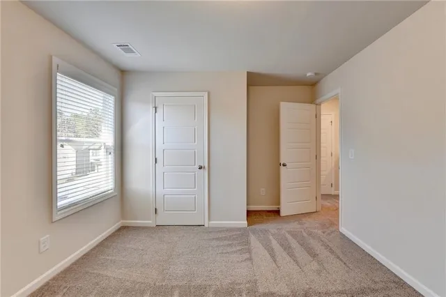 an empty room with windows and closet
