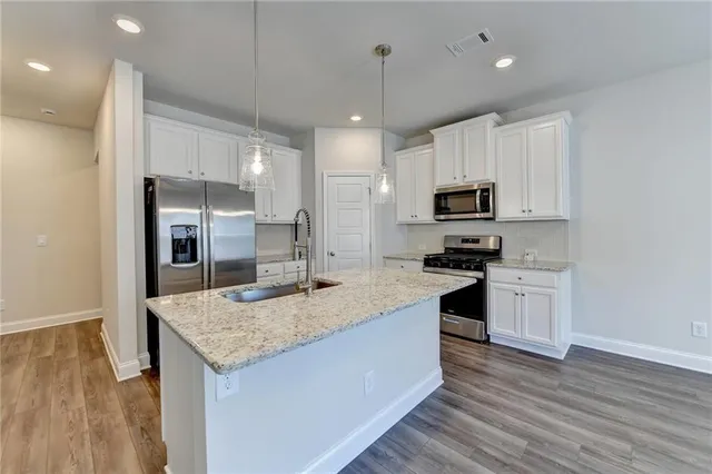 a kitchen with kitchen island granite countertop a sink and microwave