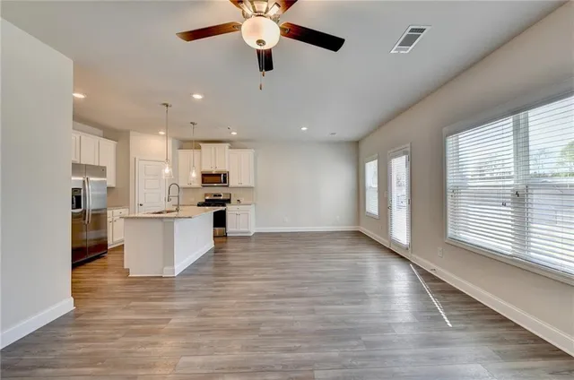 a view of kitchen with refrigerator microwave and stove top oven