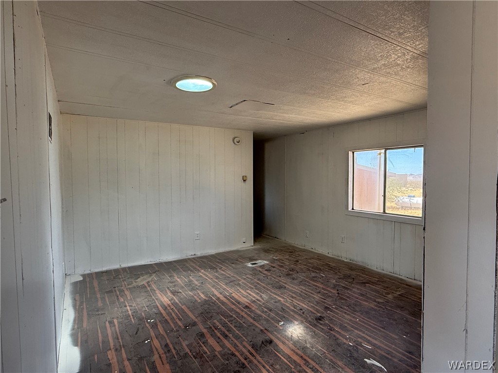 8051 7th Street Dolan Springs, AZ 86441 - Photo 17 of 65 a view of an empty room with wooden floor and a window