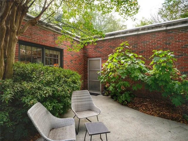 a view of a chair and table in backyard of the house