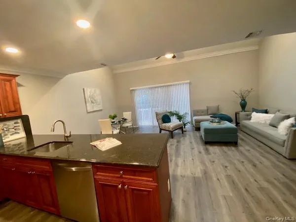 a living room with furniture a large window and wooden floor