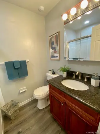 a bathroom with a granite countertop toilet sink and mirror