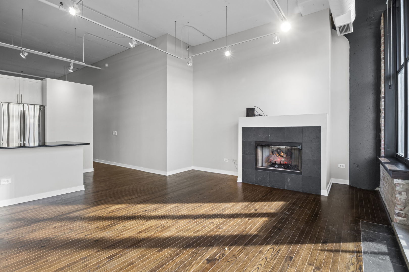 333 West Hubbard Street, Unit 502 Chicago, IL 60654 - Photo 5 of 18 a view of empty room with wooden floor and fireplace