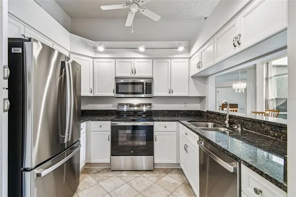 a kitchen with stainless steel appliances granite countertop a refrigerator sink and stove