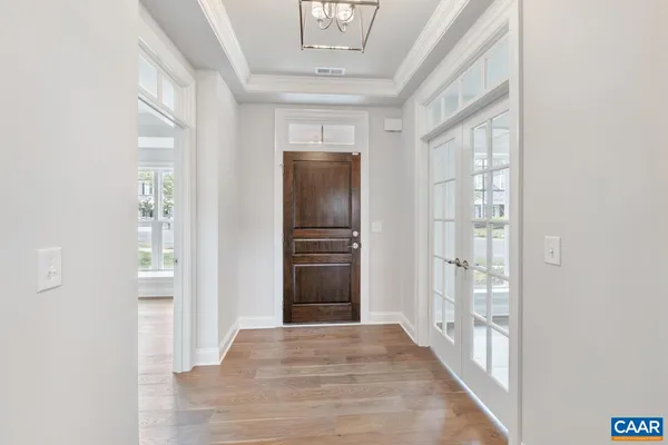 a view of a hallway with wooden floor and a living room