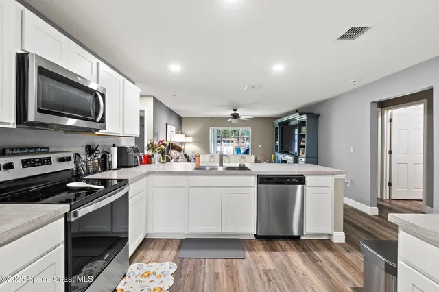 a kitchen with stainless steel appliances a stove sink microwave and cabinets