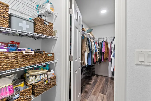 a view of walk in closet with clothes and shoes