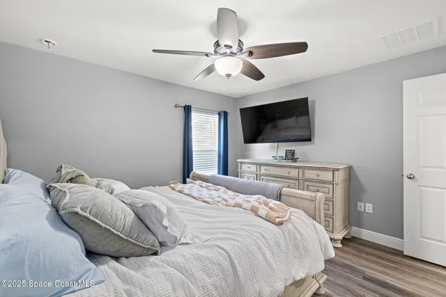 a bedroom with a bed tv and a window