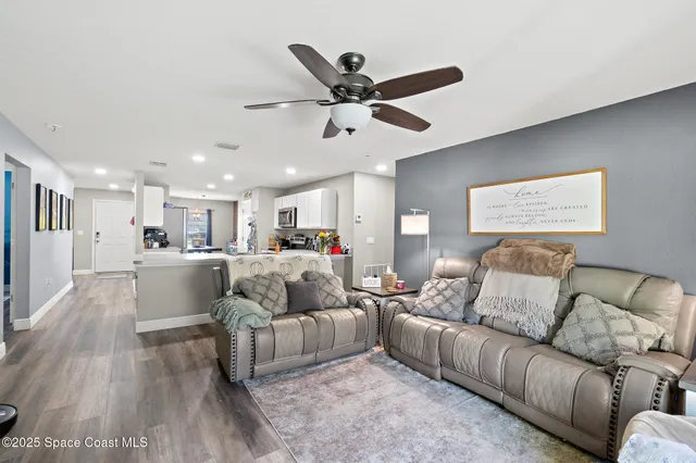 a living room with furniture and a ceiling fan
