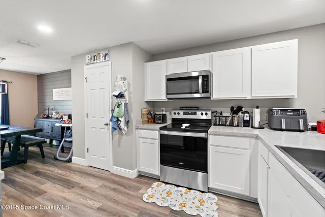 a kitchen with stainless steel appliances a stove a sink a microwave a refrigerator and cabinets