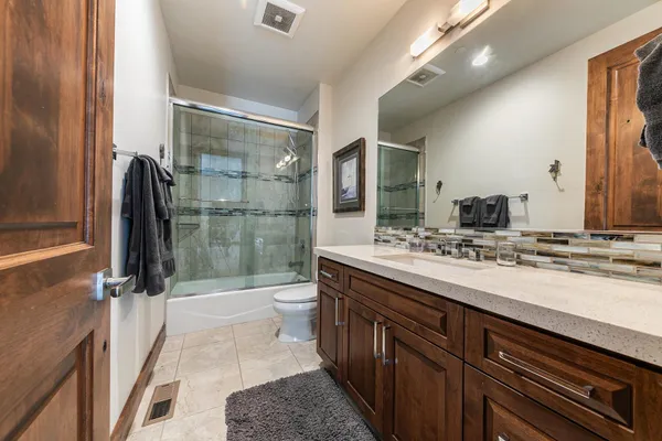 a bathroom with a sink a toilet a mirror and shower