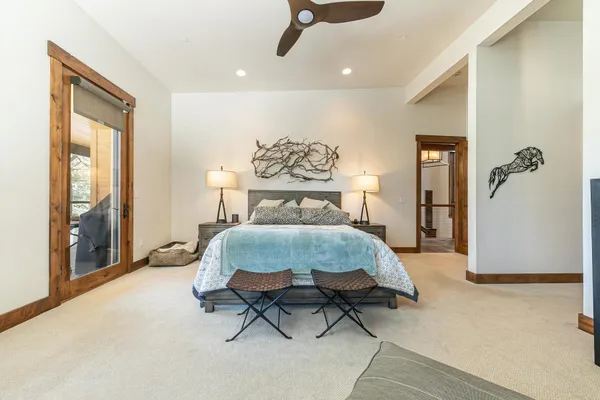 a spacious bedroom with a bed and glass door