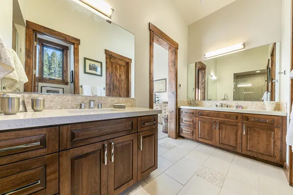 a spacious bathroom with a granite countertop double sink and a mirror