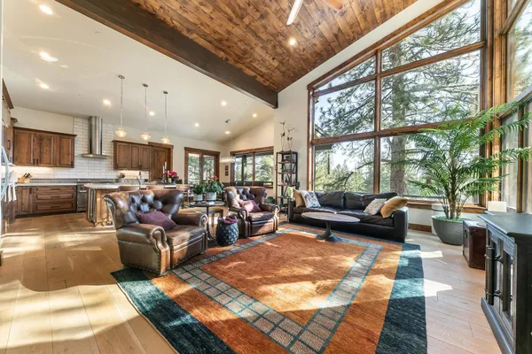 a living room with furniture kitchen view and a large window