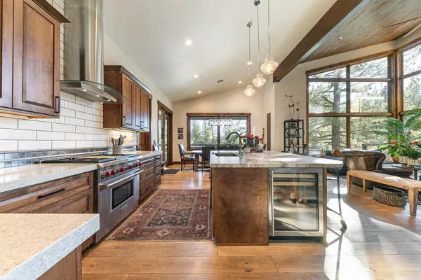 a kitchen with stainless steel appliances granite countertop a stove and a view of living room