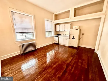 a view of a room with wooden floor and a window