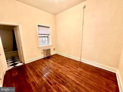 a view of a room with wooden floor and a window