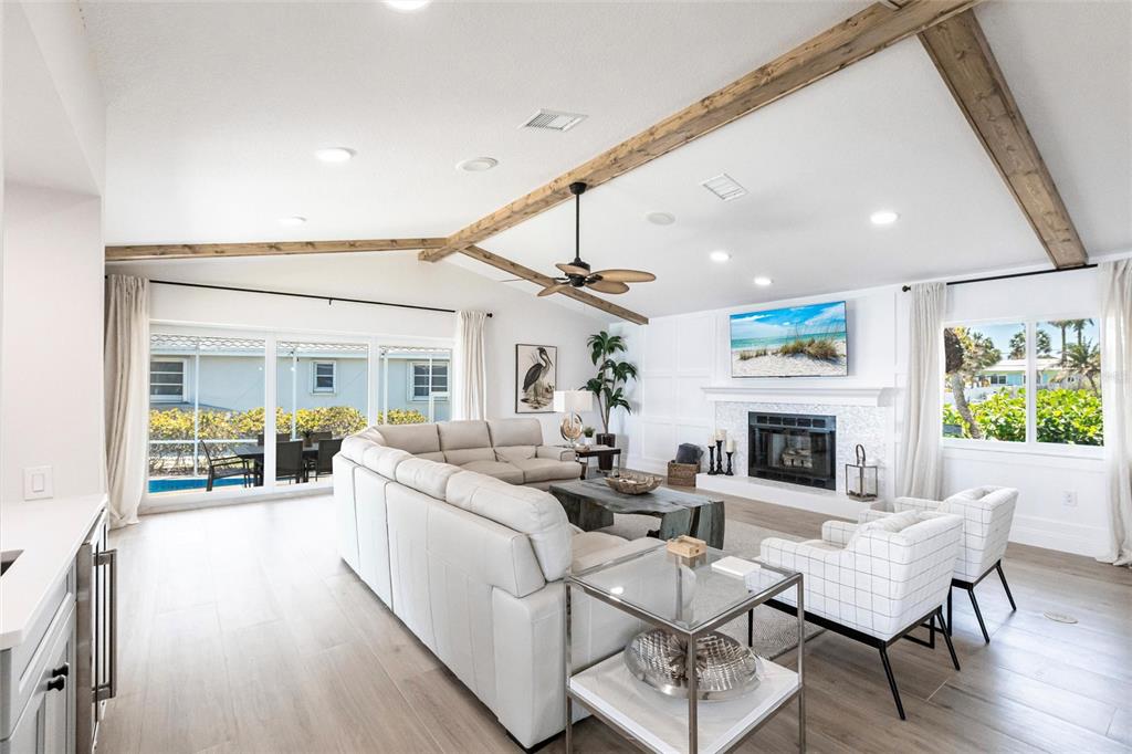 8115 Manasota Key Road Englewood, FL 34223 - Photo 22 of 67 a living room with furniture a fireplace and a floor to ceiling window