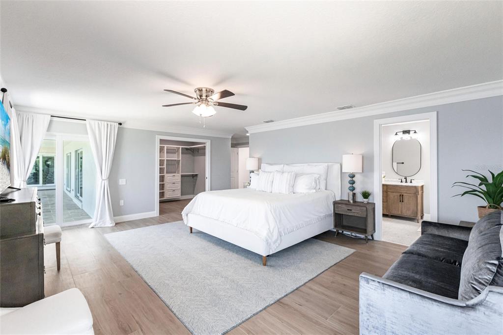 8115 Manasota Key Road Englewood, FL 34223 - Photo 38 of 67 a bedroom with a large bed and a chandelier