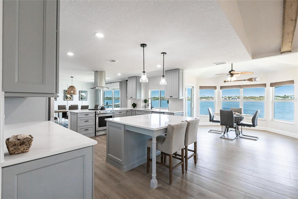 8115 Manasota Key Road Englewood, FL 34223 - Photo 4 of 67 a kitchen with a sink a stove and chairs
