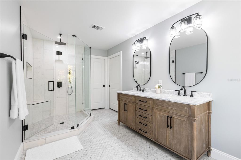 8115 Manasota Key Road Englewood, FL 34223 - Photo 41 of 67 a bathroom with a double vanity sink mirror bathtub and shower