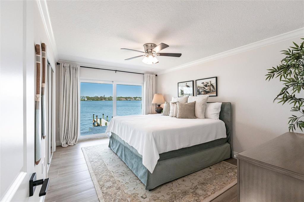 8115 Manasota Key Road Englewood, FL 34223 - Photo 54 of 67 a bedroom with a large bed and a chandelier