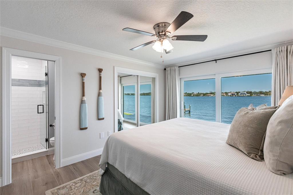 8115 Manasota Key Road Englewood, FL 34223 - Photo 55 of 67 a bedroom with a large bed and a chandelier