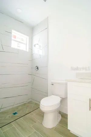 a bathroom with a toilet and a shower