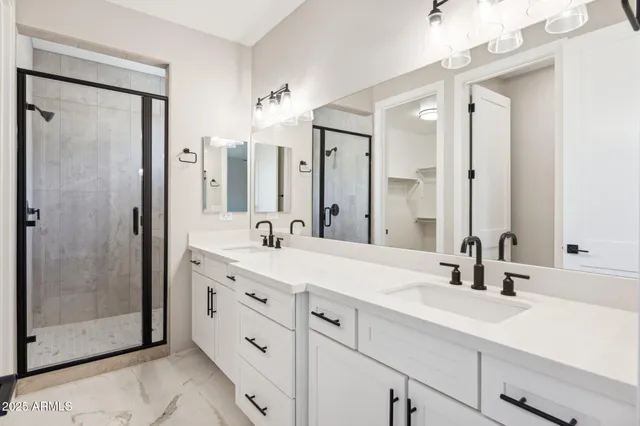 a bathroom with double vanity sinks a shower and a mirror