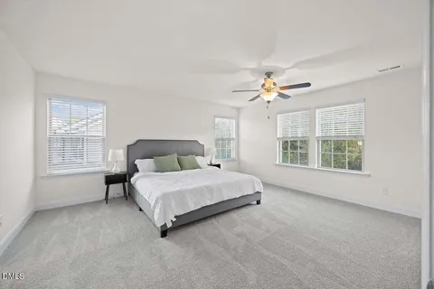 a spacious bedroom with a bed and a large window