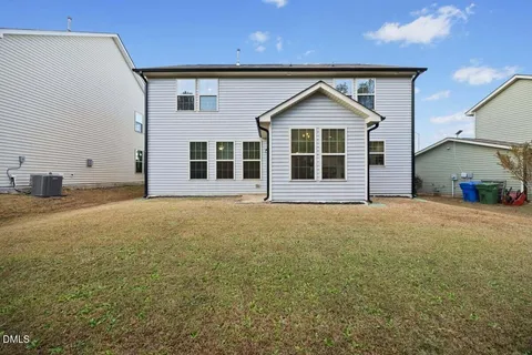 a view of a house with wooden deck and a yard