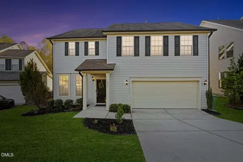a front view of a house with a garden and plants