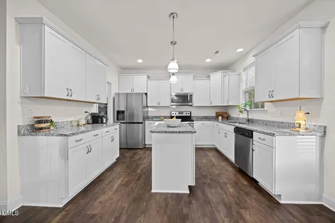 a kitchen with granite countertop white cabinets and white appliances