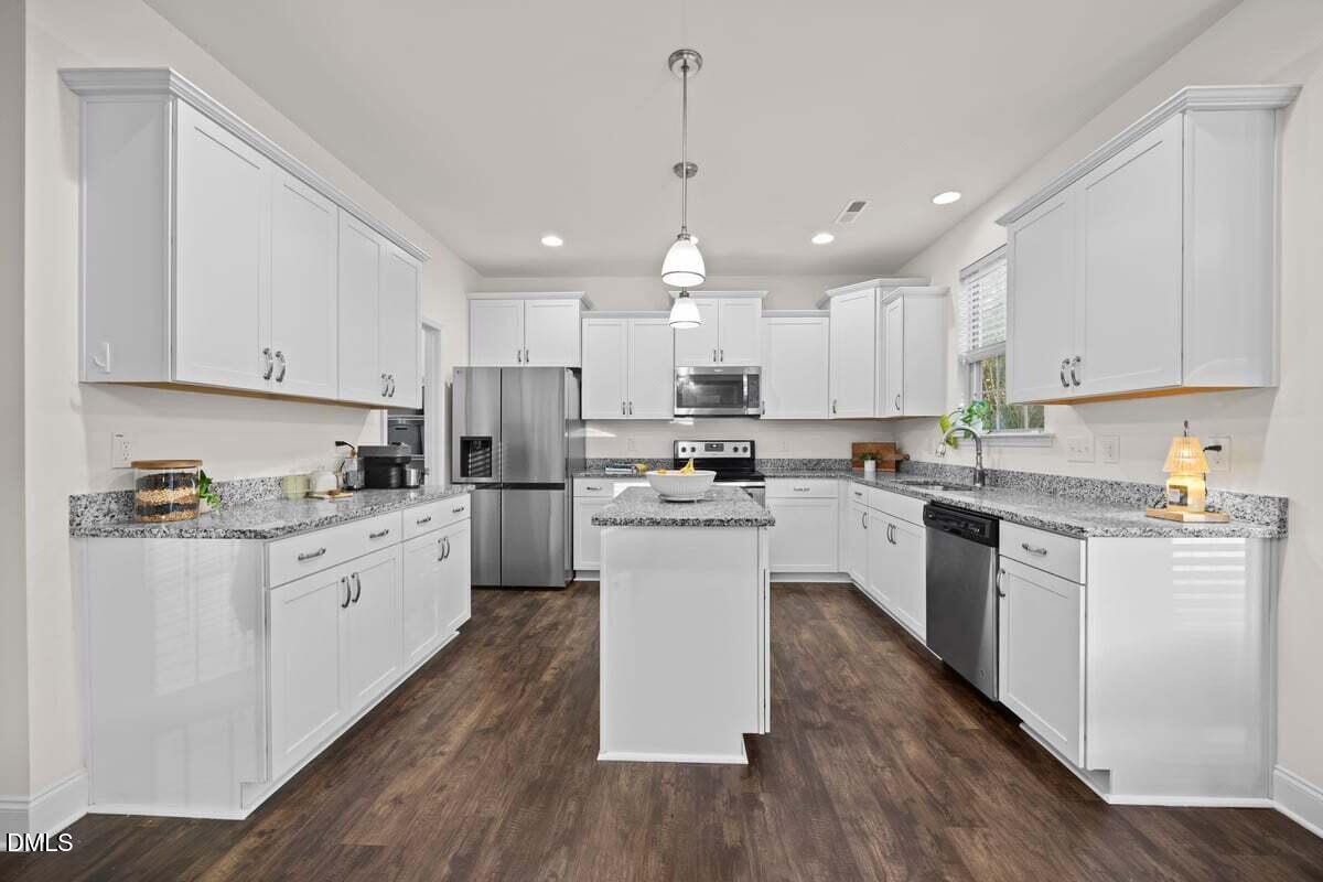 917 Stable Fern Drive Fuquay-Varina, NC 27526 - Photo 7 of 31 a kitchen with granite countertop white cabinets and white appliances