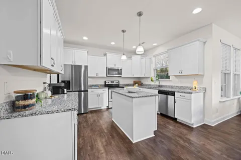 a kitchen with a refrigerator a sink and cabinets